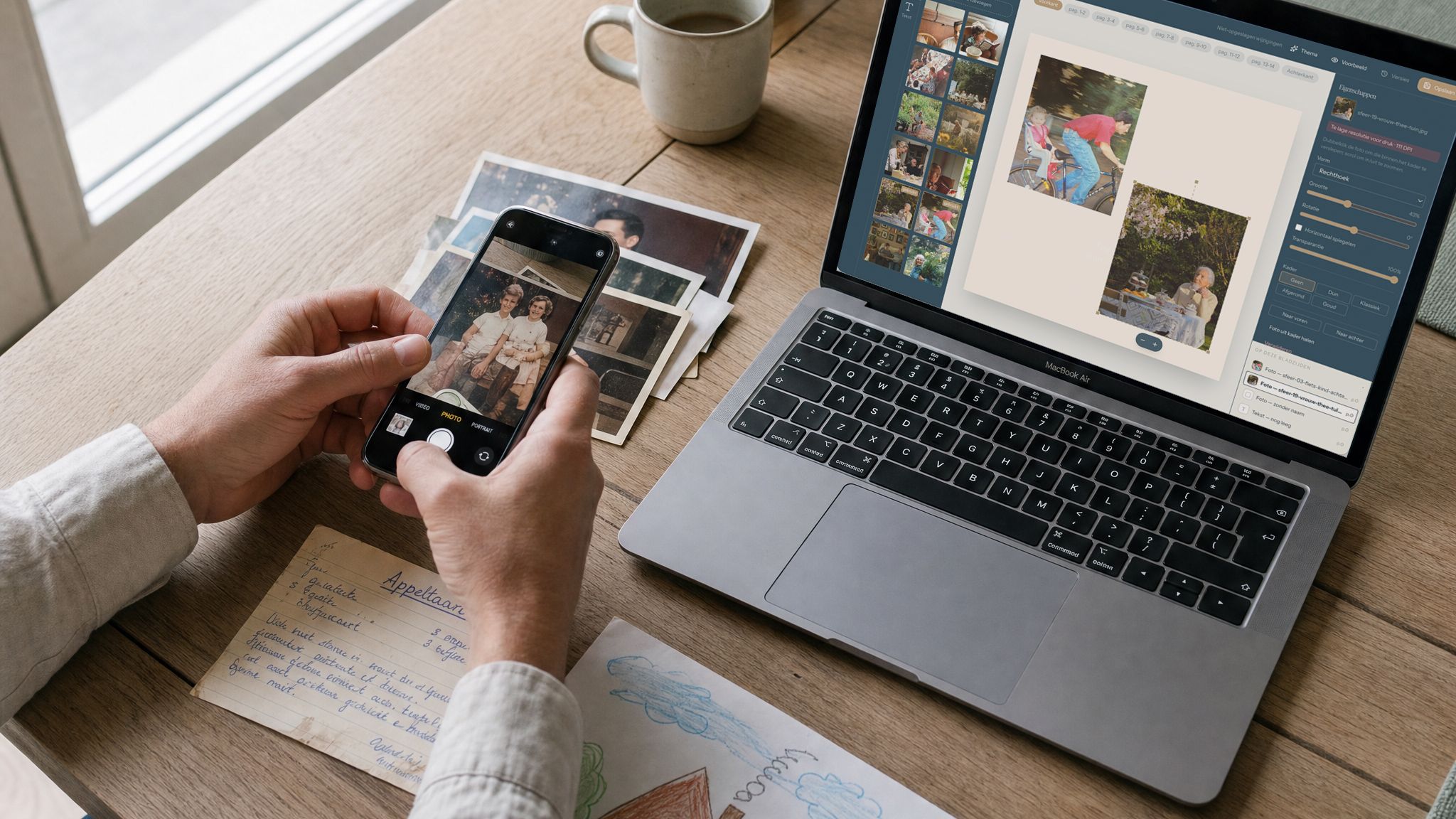 Iemand fotografeert oude foto's naast een laptop met de editor